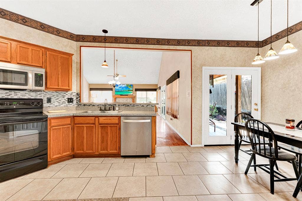 Symmetrical sightlines connect the kitchen counter pass-through and the adjacent glass doors to the living room and patio. It makes hosting buffet-style dinner parties a breeze, letting guests move freely between indoor and outdoor spaces.