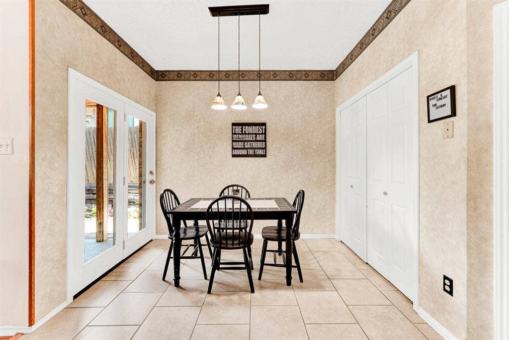 Full-lite glass doors flood this dedicated dining nook with natural light while providing direct outdoor access. It is the perfect cozy corner to savor a peaceful morning coffee while watching the backyard wake up