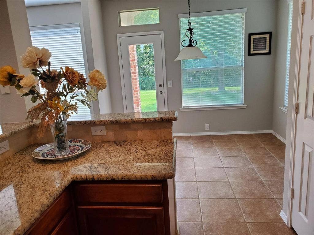2077 Sleepy Hollow Trail, Frisco, TX 75033 Kitchen featuring light tile patterned floors, hanging light fixtures, and light stone countertops