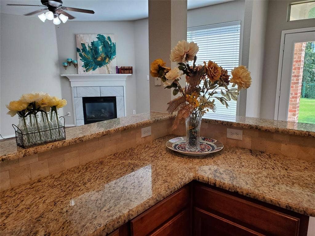 2077 Sleepy Hollow Trail, Frisco, TX 75033 Interior details with ceiling fan and a tile fireplace