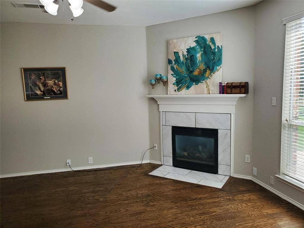 2077 Sleepy Hollow Trail, Frisco, TX 75033 Unfurnished living room featuring ceiling fan, a fireplace, wood-type flooring, and a wealth of natural light