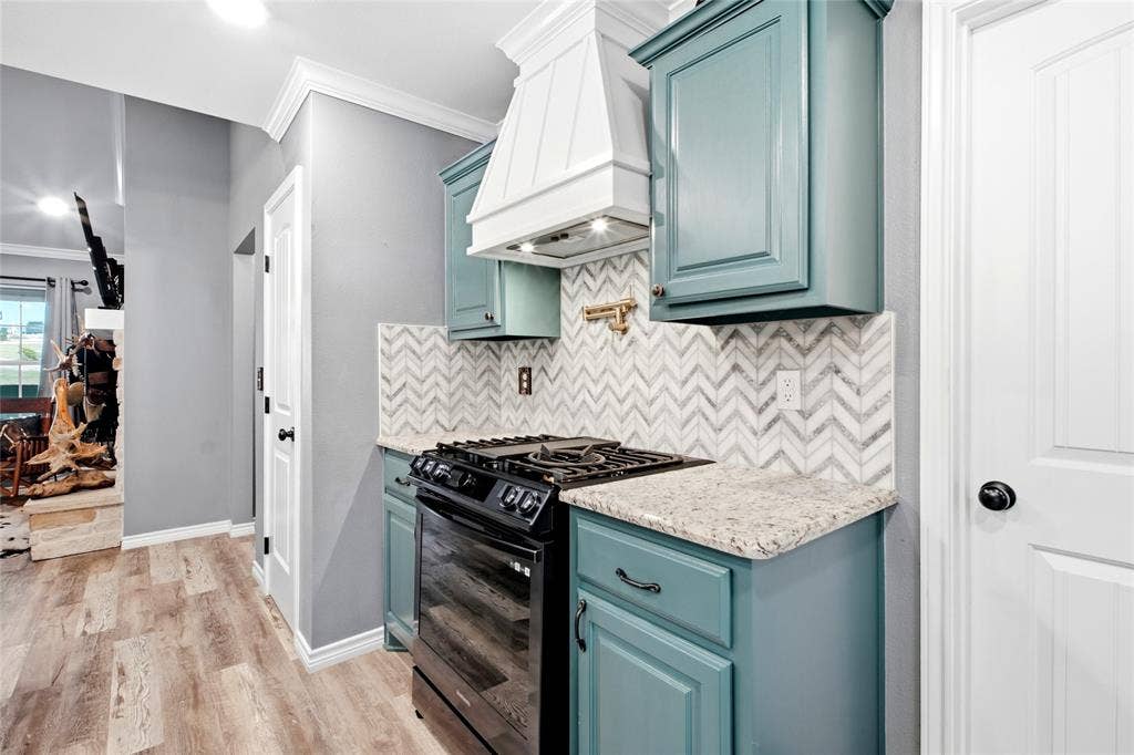 Gas range, custom vent a hood, herringbone backsplash