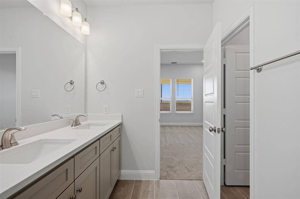 Dual vanity with integrated sinks, brushed nickel faucets, and under-sink cabinetry