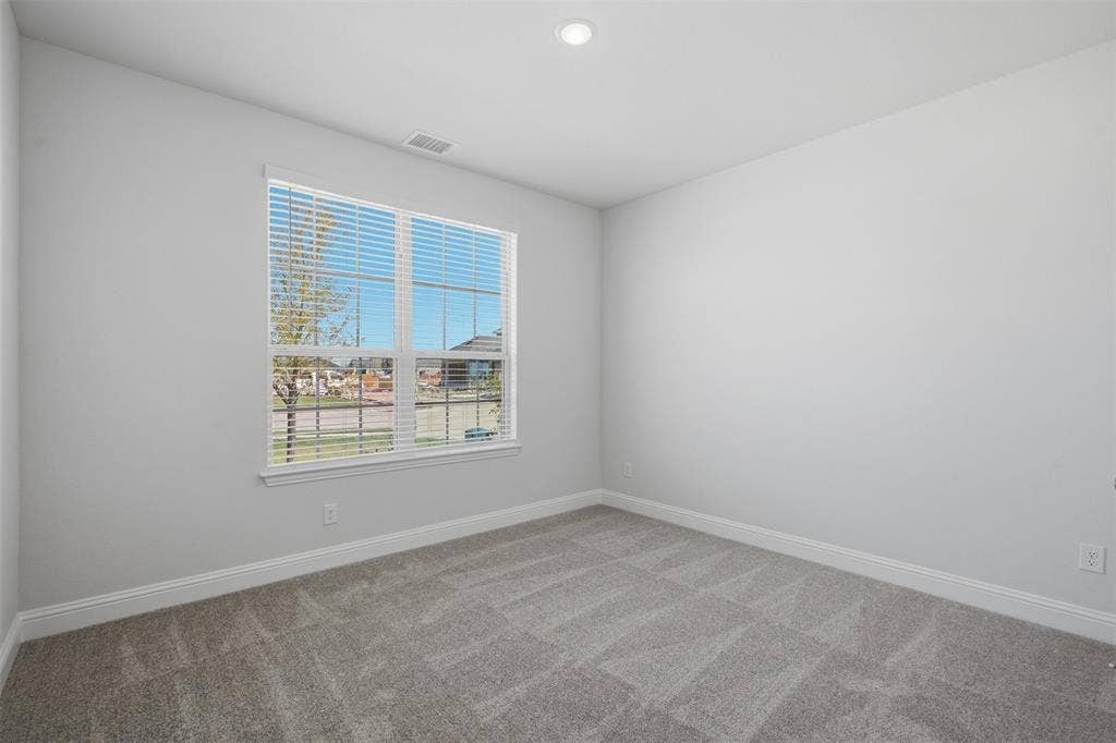 Recessed ceiling light, carpeted flooring, window with blinds, white wall finish, and white trim