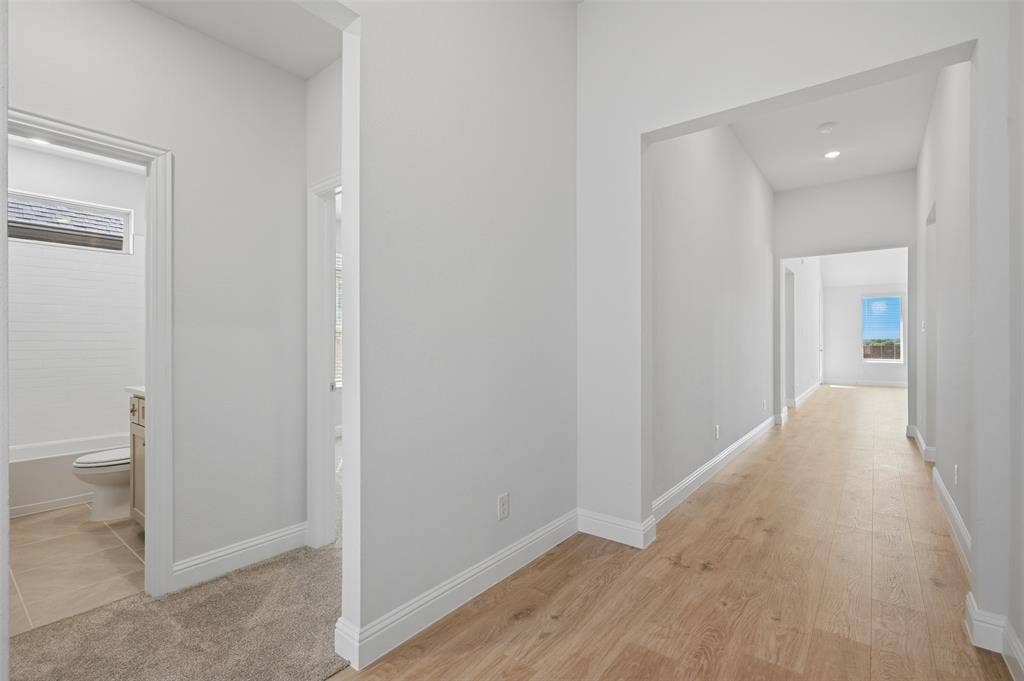 Hallway with wood-finish flooring and recessed lighting