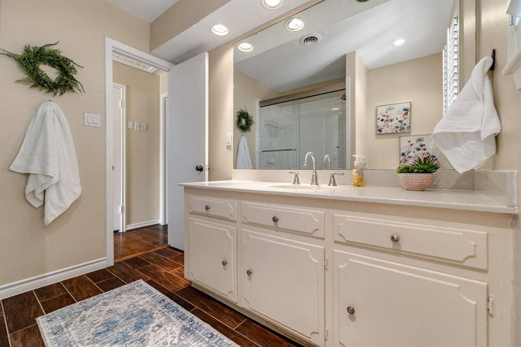 824 Westwood Drive, Richardson, TX 75080 Another view of the guest bathroom showing the large vanity, reccessed lighting and wood like ceramic tile.