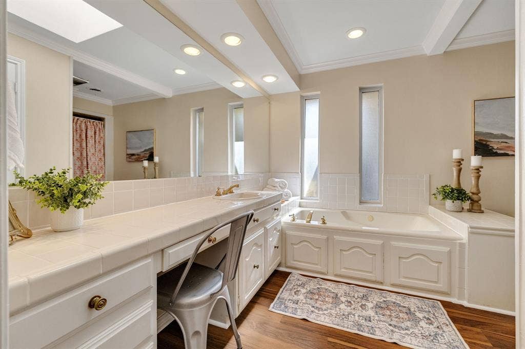 824 Westwood Drive, Richardson, TX 75080 The ensuite primary bathroom is generously sized especially for a W. Richardson home. It boasts new wood like vinyl flooring, a jetted tub and separate shower.