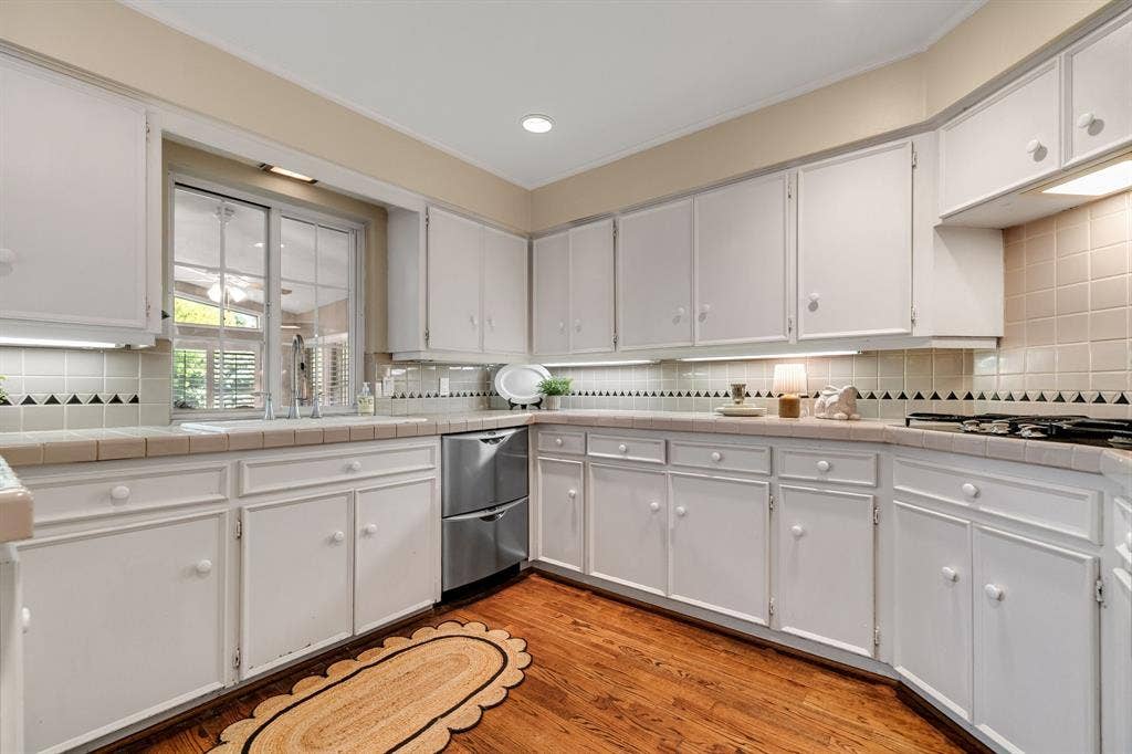 824 Westwood Drive, Richardson, TX 75080 Lots of counters pace and cabinetry to work with in this kitchen! Notice the drawer style stainless steel dishwasher and the wood floors that continue.