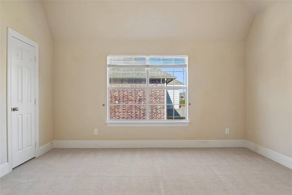 Carpeted room featuring a single window and a paneled door