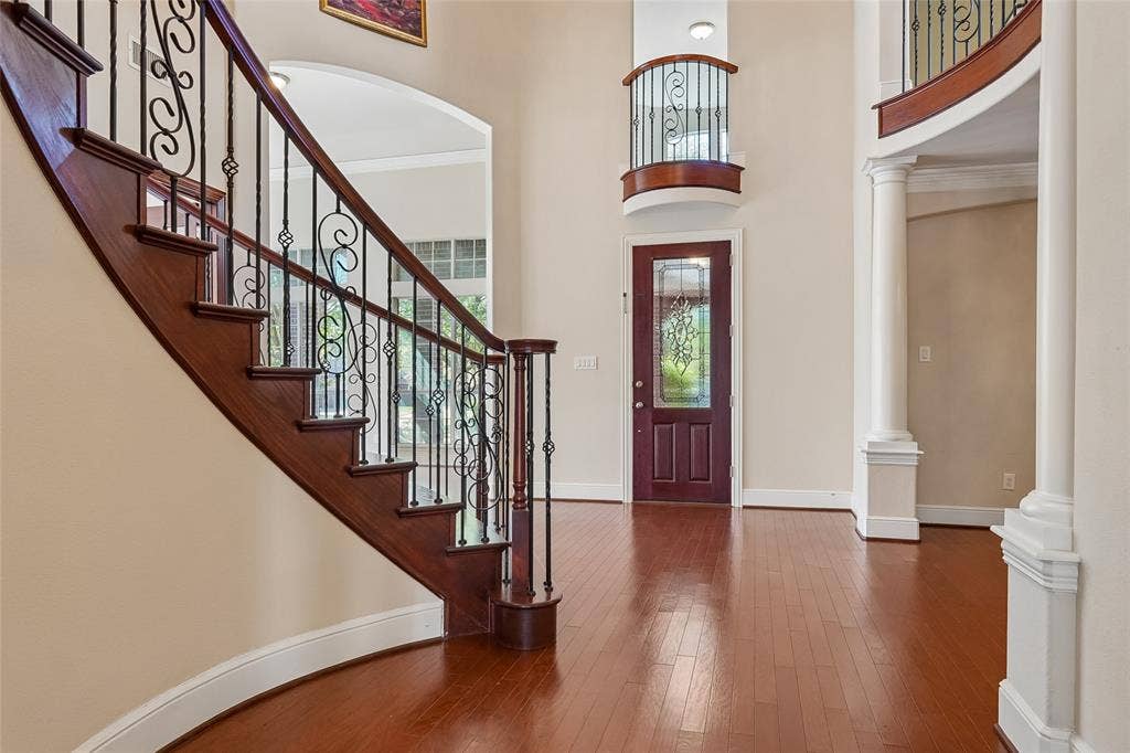 Curved staircase with wood treads and wrought iron balusters