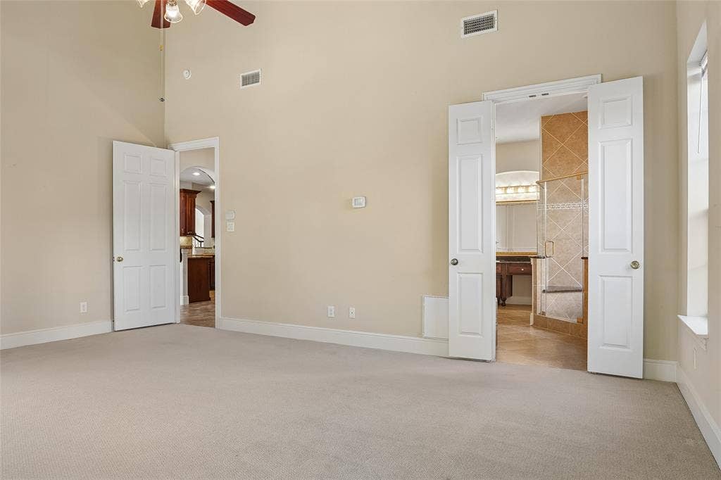 Spacious room with vaulted ceilings and a ceiling fan