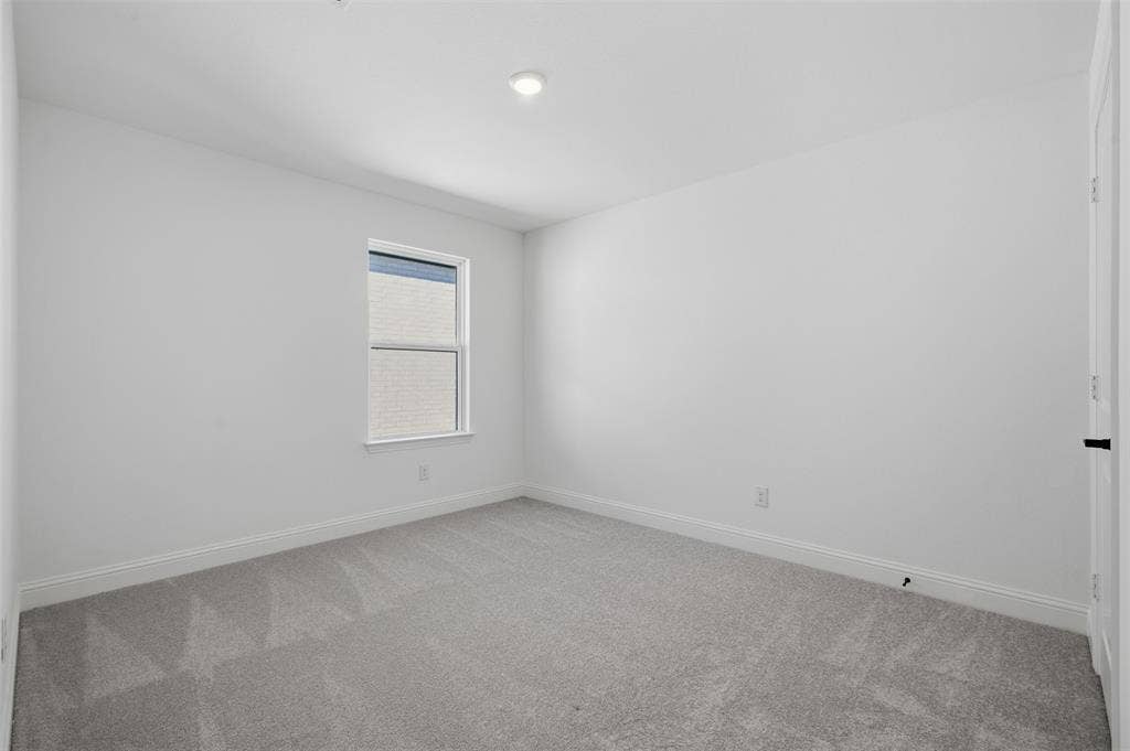 Neutral wall color, recessed ceiling light, window with exterior brick detail, gray carpet, and baseboard molding