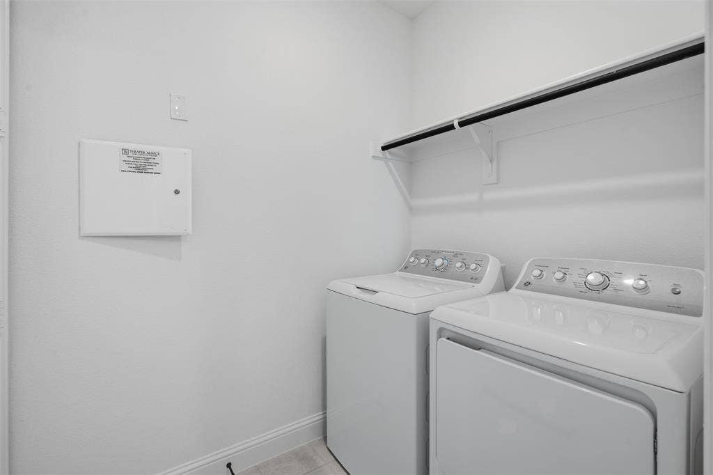 Laundry area with white walls, a built-in shelf, and a clothing rod