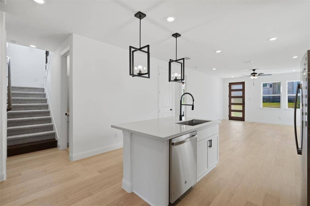 Central kitchen island with an undermount sink and stainless steel dishwasher
