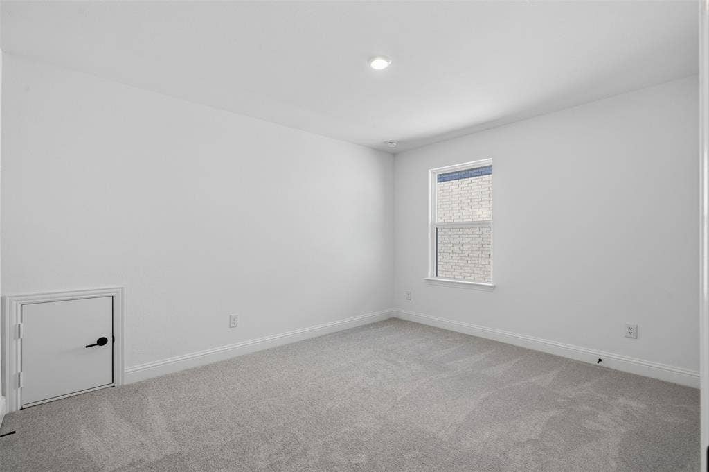 Recessed lighting, white walls, gray carpeting, a single window, and a built-in access panel