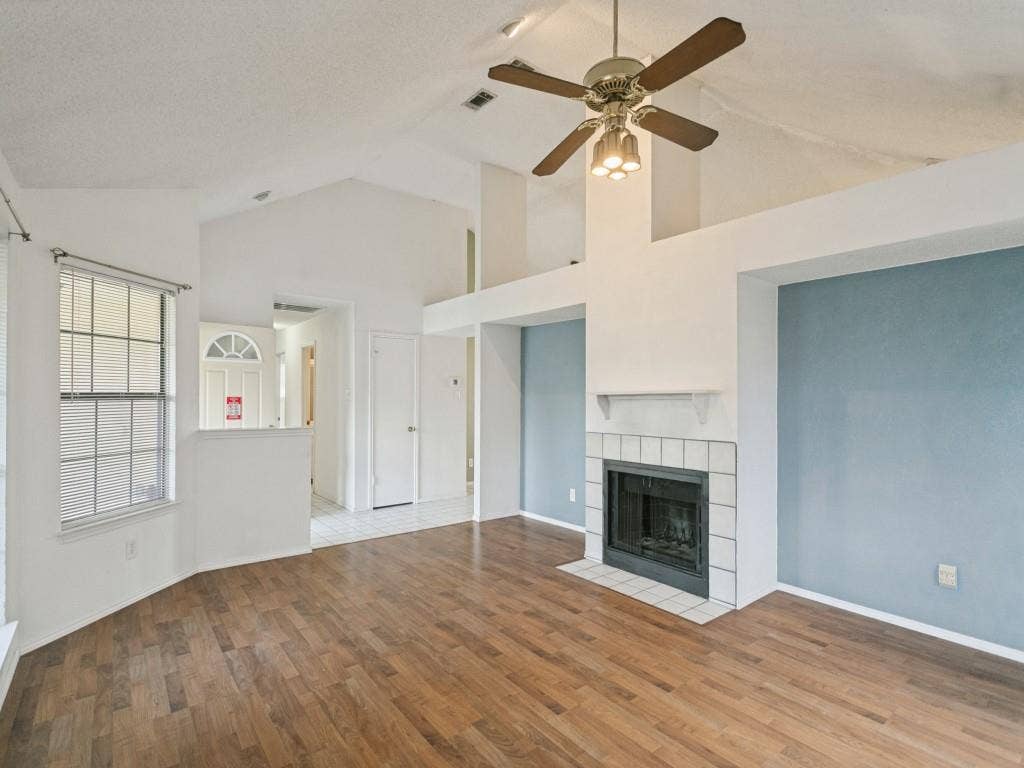 714 Bluebonnet Drive, Allen, TX 75002 Vaulted ceilings, wood-finish flooring, masonry fireplace with tile surround, built-in mantle, and multi-paned window