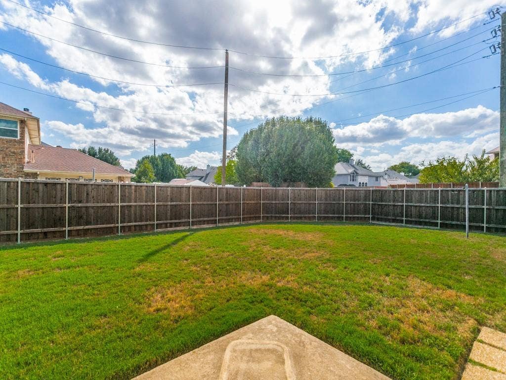 714 Bluebonnet Drive, Allen, TX 75002 Backyard featuring a grass lawn, perimeter wood fencing, and a concrete patio slab