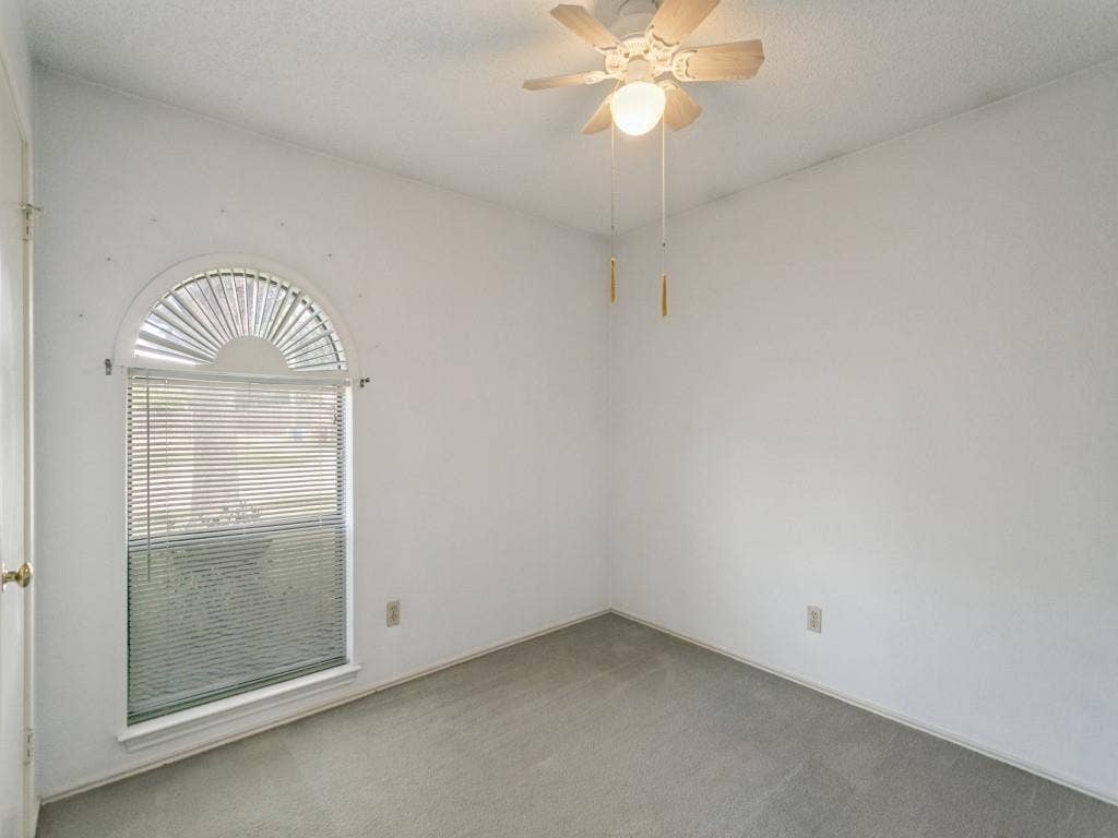 714 Bluebonnet Drive, Allen, TX 75002 Bedroom 2 featuring an arched window and a ceiling-mounted fan with integrated lighting
