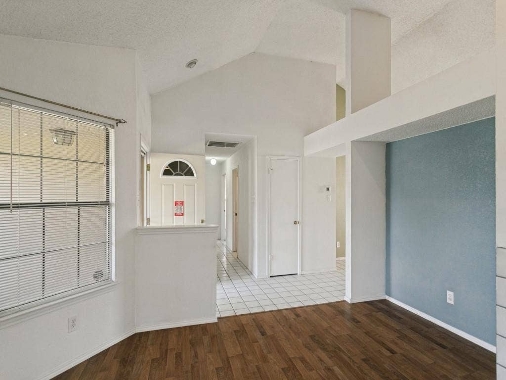 714 Bluebonnet Drive, Allen, TX 75002 Vaulted ceilings, wood-finish flooring, ceramic tile entryway, and architectural accent wall