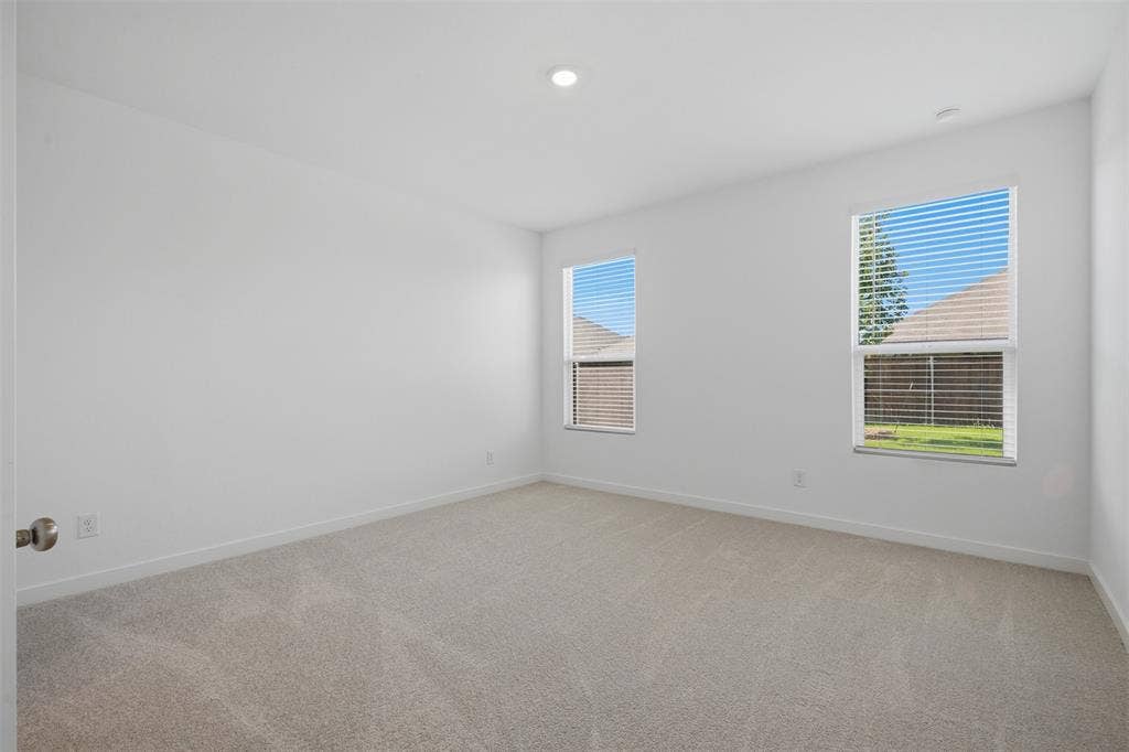 7117 Black Cherry Lane, McKinney, TX 75071 Recessed lighting, neutral wall paint, two windows with blinds, and light-toned carpeting