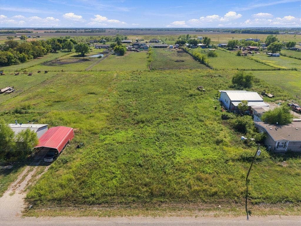 276 Winding River Circle, Farmersville, TX 75442 Expansive grassy acreage with a red metal carport and a large outbuilding