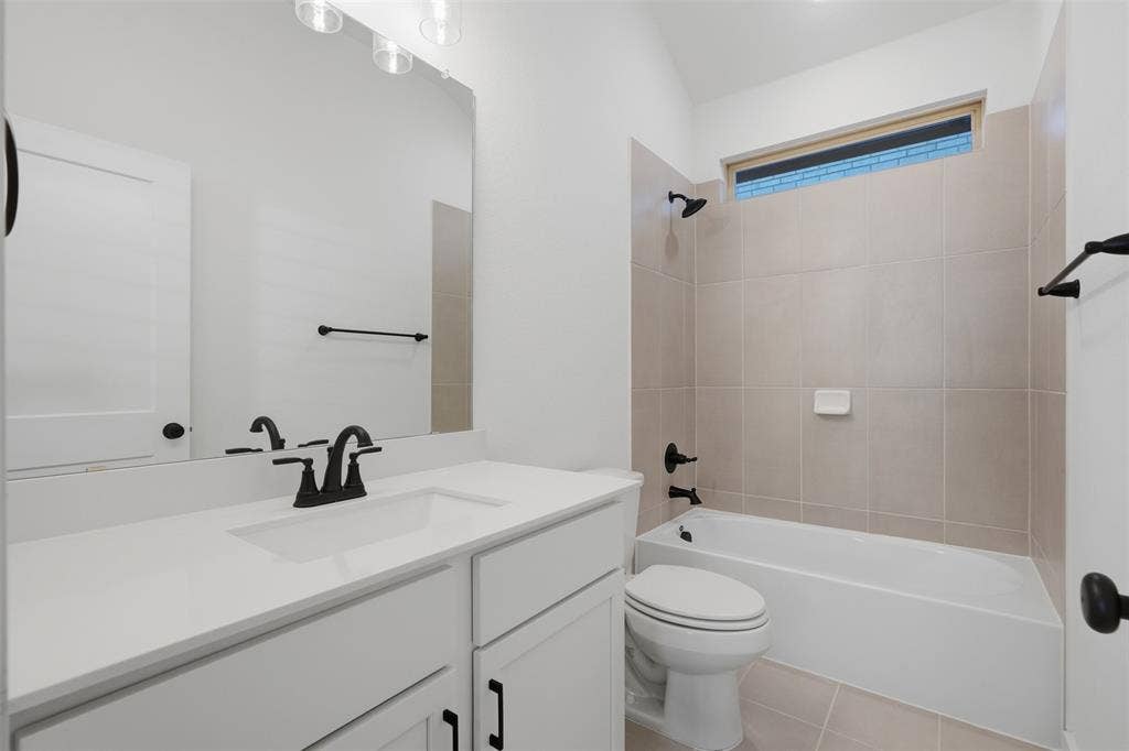 White single vanity with an integrated sink, black fixtures, and a large wall mirror