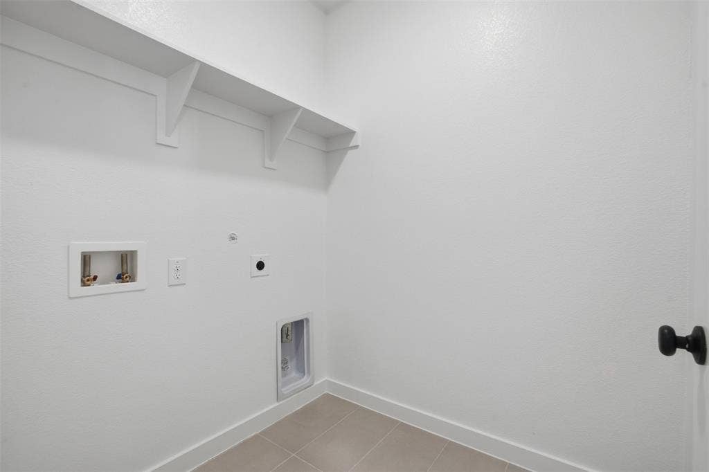Laundry area with built-in shelving, tile flooring, and utility hookups