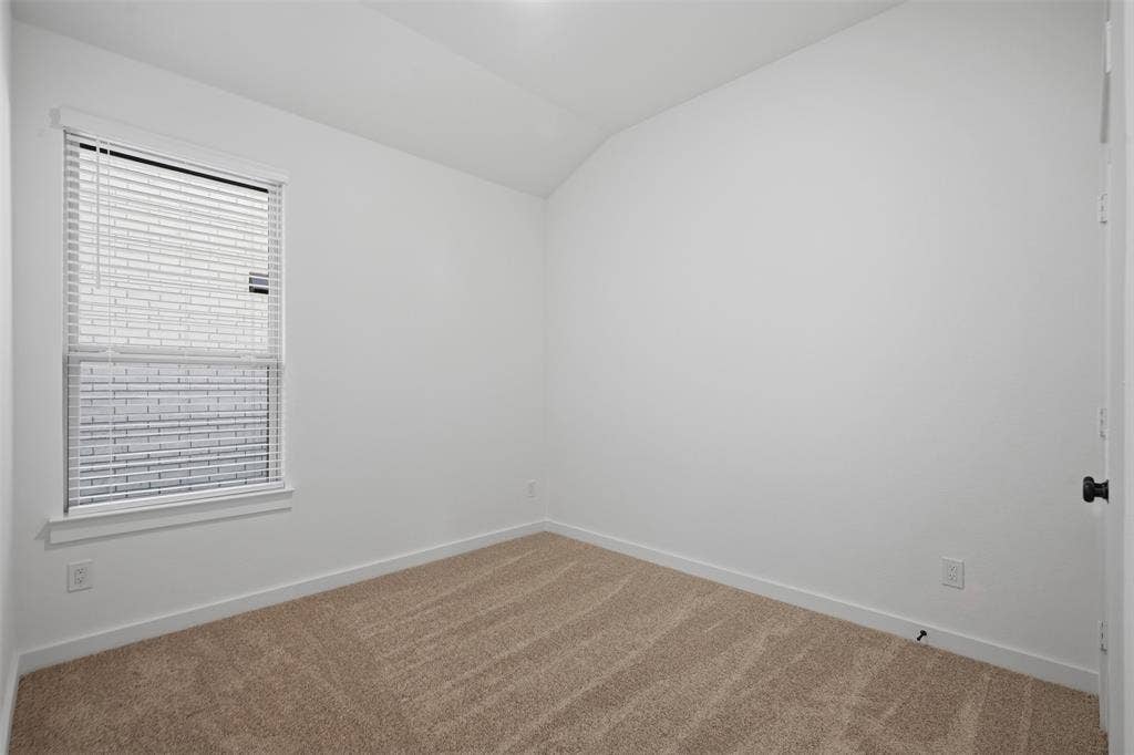 Wall-to-wall carpeting, single window with blinds, and neutral wall paint