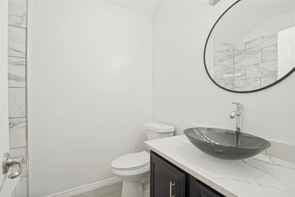 2815 Briarbrook Drive, Seagoville, TX 75159 Vanity with a vessel sink, a chrome-finish faucet, and a round mirror