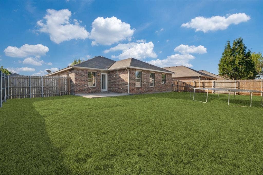 2815 Briarbrook Drive, Seagoville, TX 75159 Expansive green lawn, brick exterior, paved patio, and privacy fencing
