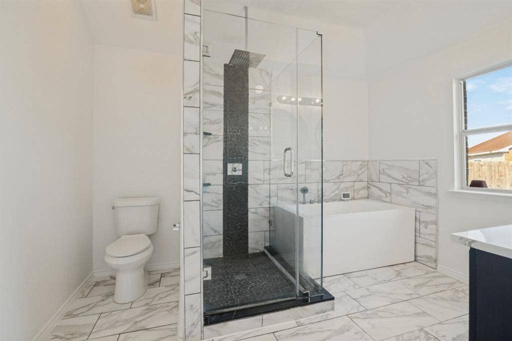 2815 Briarbrook Drive, Seagoville, TX 75159 Glass-enclosed shower with black tile surround, white soaking tub, and white tile flooring