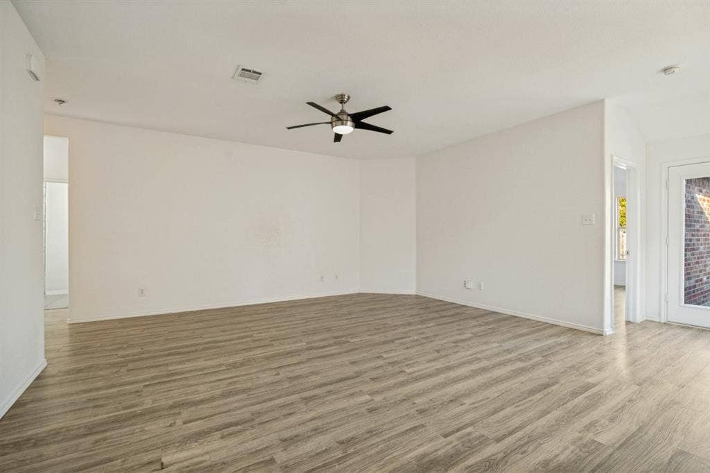 2815 Briarbrook Drive, Seagoville, TX 75159 Spacious room featuring wood-finish flooring, a ceiling fan with integrated lighting, and white painted walls