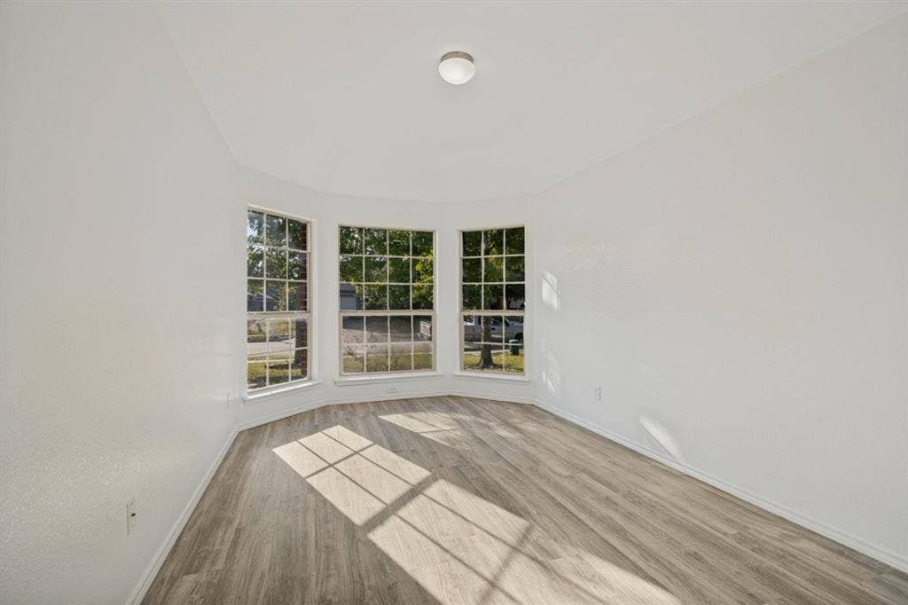 2815 Briarbrook Drive, Seagoville, TX 75159 Bay window with multiple panes, wood-finish flooring, and a flush-mount ceiling light