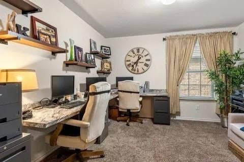 Room featuring built-in floating shelves, wall-mounted desk surfaces, a window with blinds and drapes, and carpeted flooring
