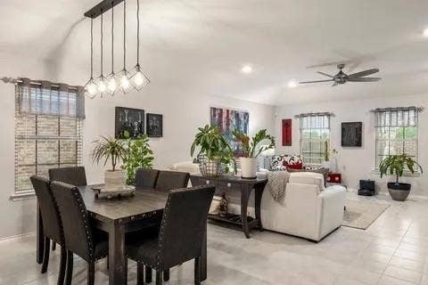 Recessed lighting with a ceiling fan, tiled flooring, multiple windows, and an open-concept living area