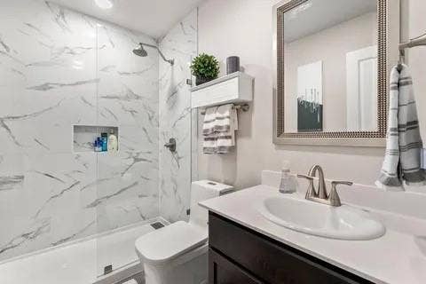 Walk-in shower with large format, marble-look wall tiles and a built-in shower niche