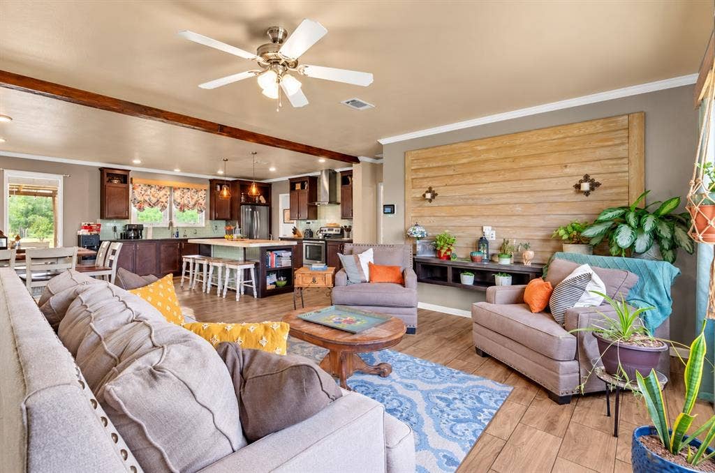 213 River Front Drive, Cedar Creek, TX 78612 Open-concept living area featuring exposed ceiling beams and wood-finish flooring