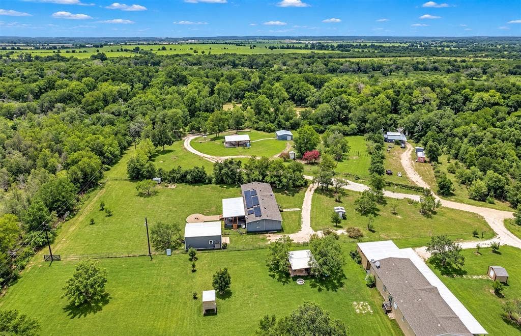 213 River Front Drive, Cedar Creek, TX 78612 Expansive green grounds with mature trees and multiple residential structures