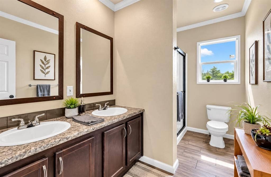 213 River Front Drive, Cedar Creek, TX 78612 Dual vanity with integrated sinks, rich wood-finish cabinetry, and stone-finish countertop