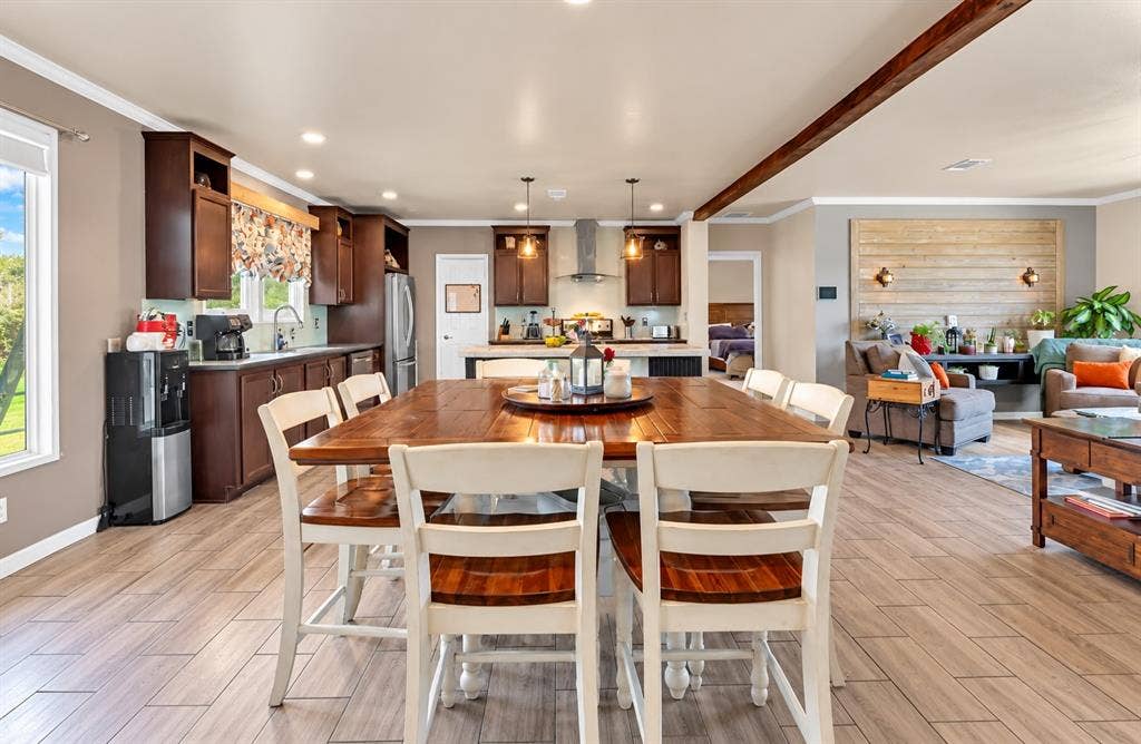 213 River Front Drive, Cedar Creek, TX 78612 Open-concept living area with wood-finish flooring, a kitchen featuring dark wood cabinetry, and a living room with a shiplap accent wall