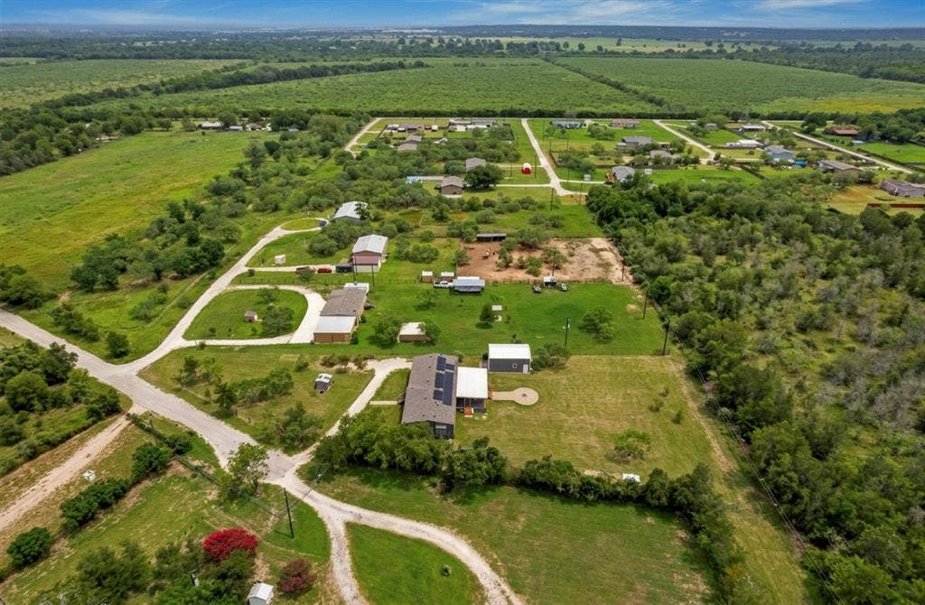 213 River Front Drive, Cedar Creek, TX 78612 Expansive green landscape with residential structures and established roads