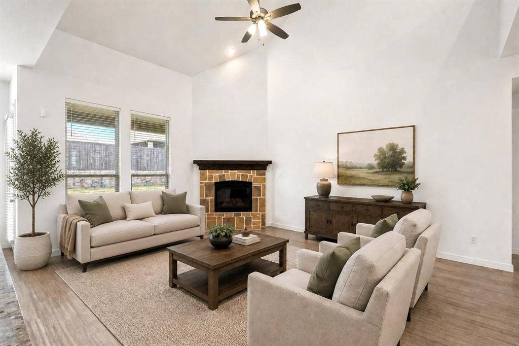 2466 San Marcos Drive, Forney, TX 75126 Vaulted ceilings, stone-surround fireplace with a dark wood mantle, wood-finish flooring, and large windows