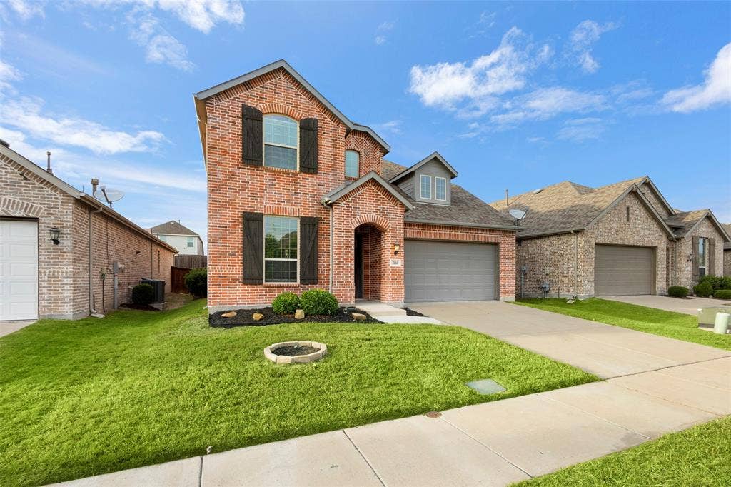 2466 San Marcos Drive, Forney, TX 75126 Two-story brick exterior featuring dark decorative shutters, a multi-gabled roofline, and an attached two-car garage