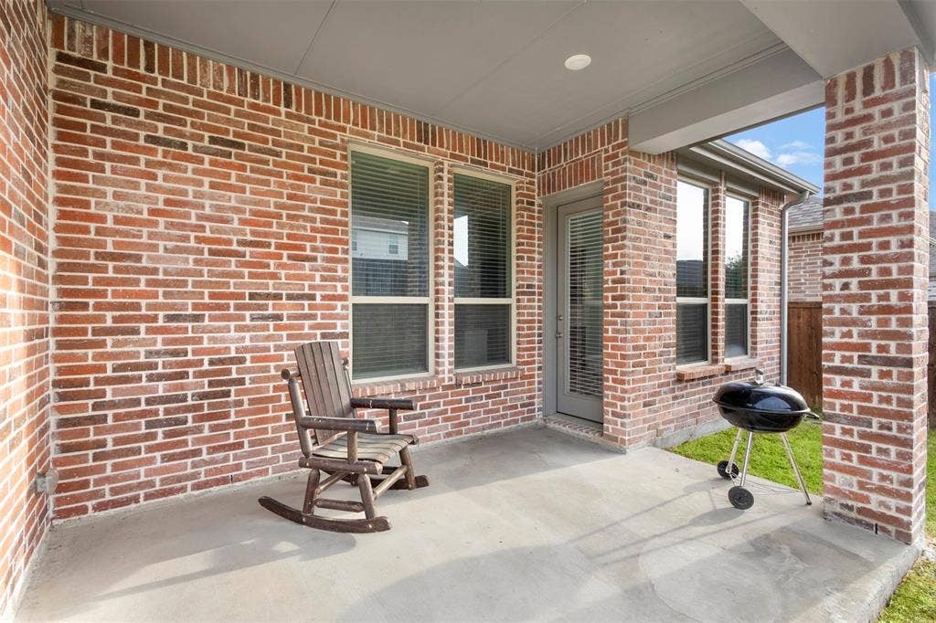 2466 San Marcos Drive, Forney, TX 75126 Covered patio featuring red brick exterior walls, a concrete floor, recessed ceiling lighting, and multiple windows