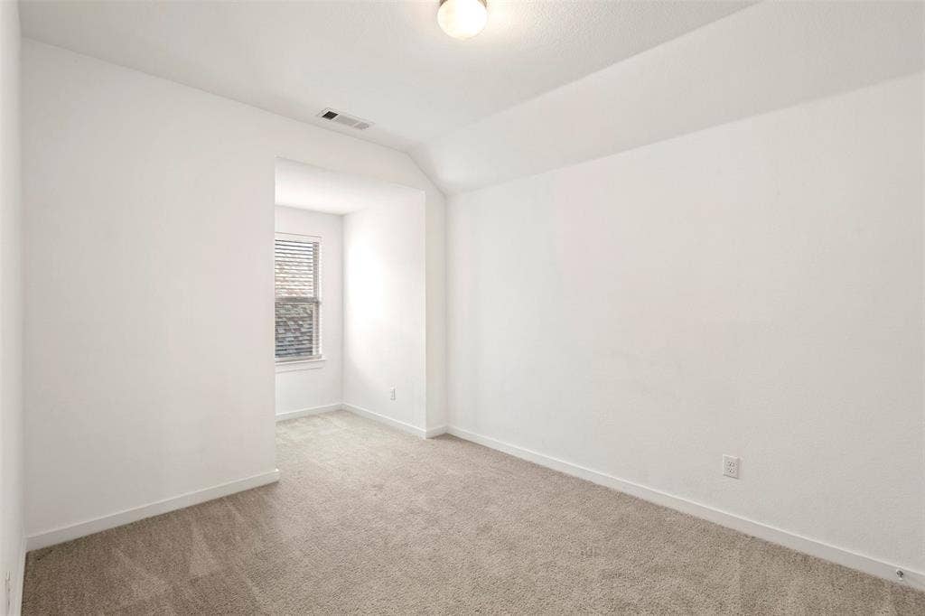 2466 San Marcos Drive, Forney, TX 75126 Interior room featuring neutral wall-to-wall carpeting, vaulted ceilings, and a recessed window nook with a single-pane window