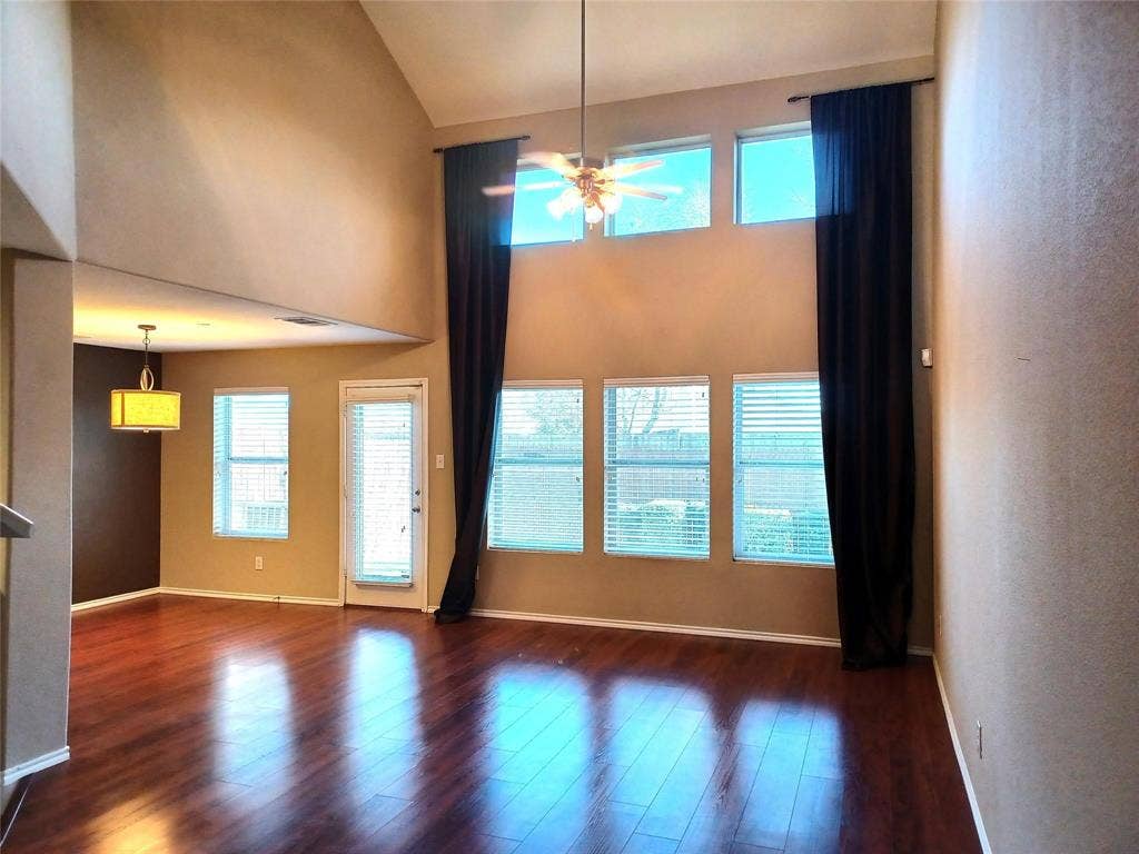 Vaulted ceilings, wood-finish flooring, abundant natural light, and a ceiling fan