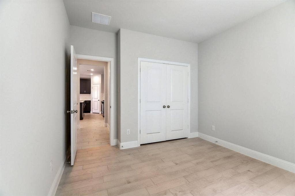 Room featuring light neutral wall tones, light wood-finish flooring, and white trim