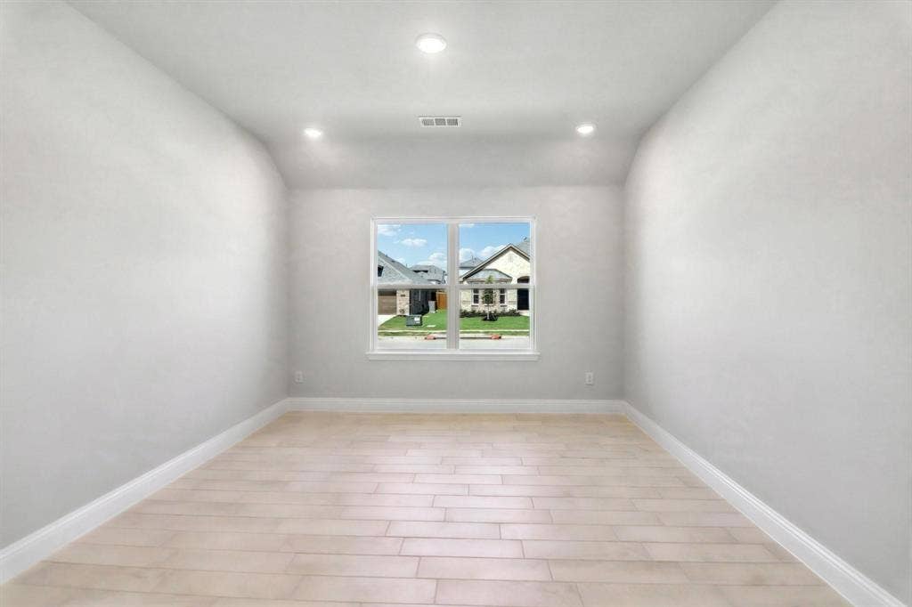 Recessed ceiling lighting, light wood-finish flooring, and a single window