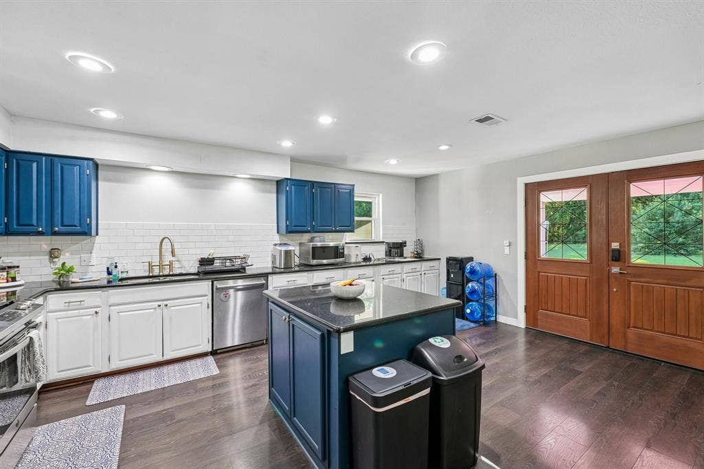 500 Spinner Road, DeSoto, TX 75115 Kitchen featuring an island with stone countertop, stainless steel dishwasher, white subway tile backsplash, recessed lighting, and wood-finish flooring