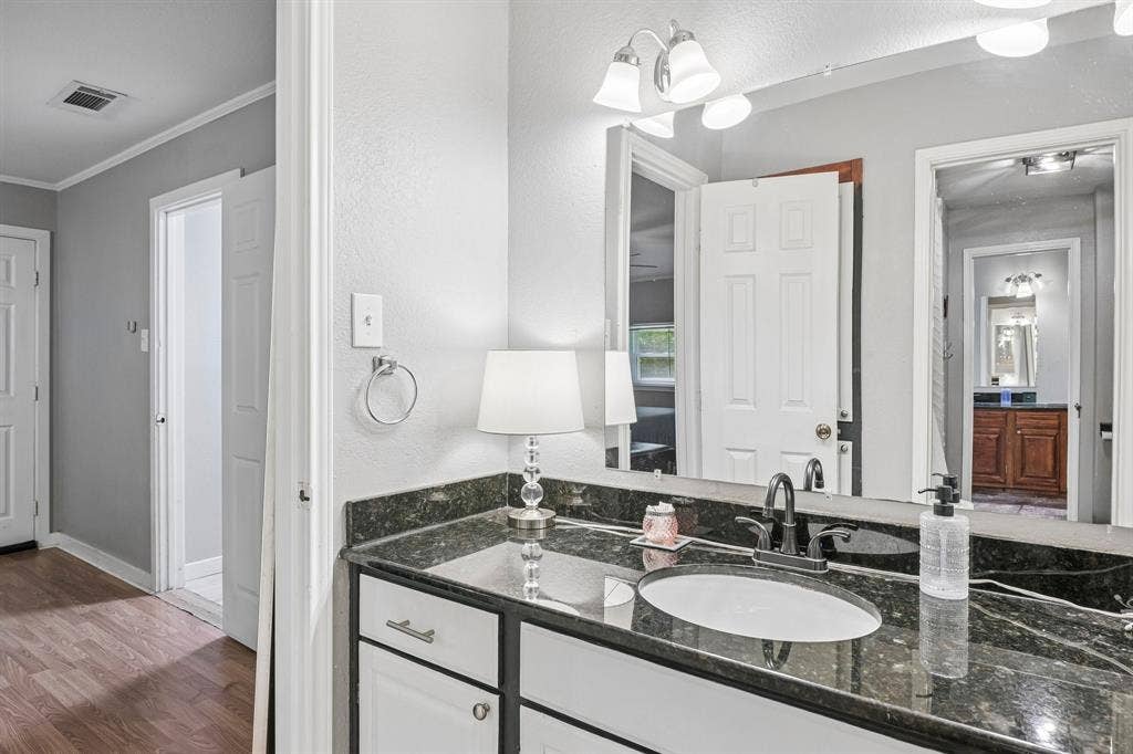 500 Spinner Road, DeSoto, TX 75115 Vanity with white cabinetry, dark countertop, and an oval undermount sink